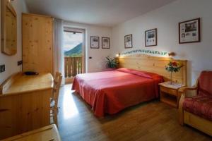a bedroom with a bed and a window and a couch at HOTEL La Locanda in Pinzolo