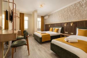 a hotel room with two beds and a desk at Taksim Peradise Hotel in Istanbul