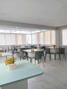a dining room with tables and chairs and windows at Hotel Porto Segur0 in Recife