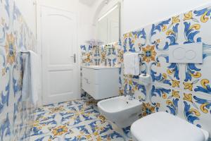 a bathroom with a toilet and blue and white tiles at Casa Consilla in Positano +52 photos