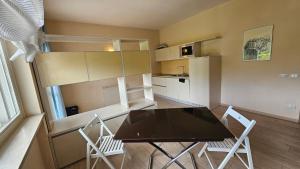 a kitchen with a table and chairs in a room at Hotel Residence Juvarra Centro Benessere in Biella