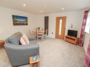 a living room with a couch and a television at Little Plumtree in Milnthorpe