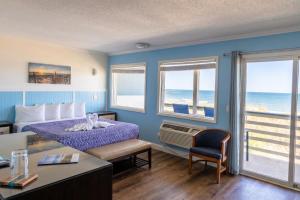 a hotel room with a bed and a view of the ocean at Blue Heron Motel in Nags Head +86 photos