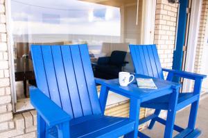 two blue chairs and a table with a coffee cup at Blue Heron Motel in Nags Head