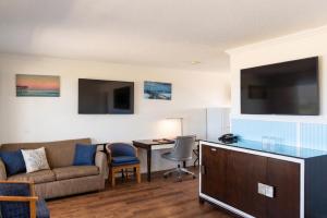 a living room with a couch and a table with a desk at Blue Heron Motel in Nags Head