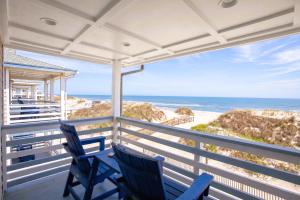 two blue chairs sitting on a porch overlooking the beach at Blue Heron Motel in Nags Head