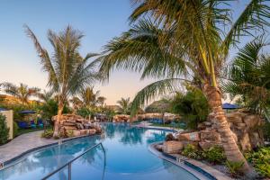 a swimming pool with palm trees in a resort at Tropical Beach Resorts - Sarasota in Sarasota