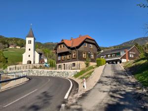 a house on the side of a road with a church at Ferienwohnung Kirchenbauer in Rieding