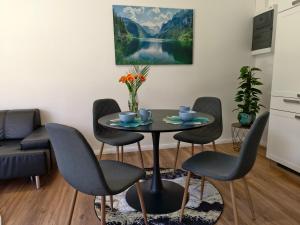 a dining room with a table and four chairs at Ferienwohnung Kirchenbauer in Rieding +17 photos