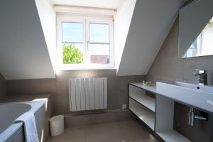 a bathroom with a sink and a window at Hotel Restaurant Père Benoît in Entzheim