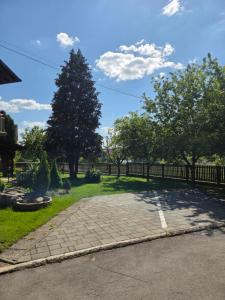 a driveway with a fence and a tree at House Bogović in Karlovac