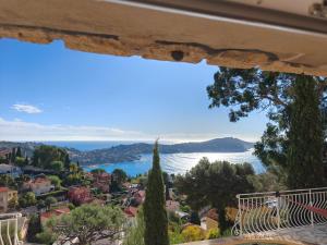 a view of a city and the ocean from a window at Studio with private pool in Villefranche-sur-Mer