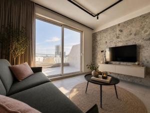 a living room with a couch and a large window at Exclusive Retreat off the Sea Front Promenade in Il-Gżira
