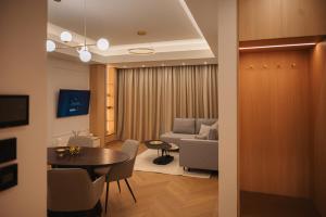 a living room with a table and a couch at Designer Suite • Pool & Sauna • Pipera Metro in Bucharest