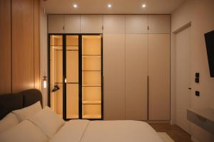 a bedroom with a white bed and a closet at Designer Suite • Pool & Sauna • Pipera Metro in Bucharest +20 photos