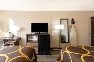 a hotel room with two beds and a flat screen tv at Mid Rest Inn Lexington NE I-80 in Lexington