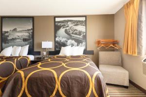 a hotel room with a bed and a chair at Mid Rest Inn Lexington NE I-80 in Lexington +29 photos