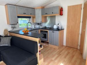 a small kitchen with gray cabinets and a black counter top at Camping paradis in Clohars-Carnoët