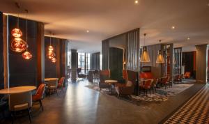 a lobby with tables and chairs in a building at Clayton Hotel, Leeds in Leeds