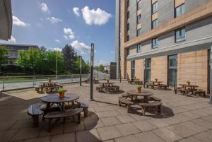 a group of tables and benches in front of a building at Clayton Hotel, Leeds in Leeds +29 photos