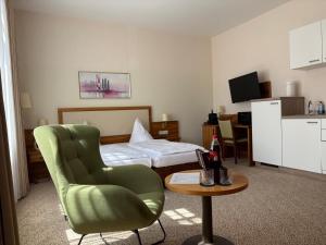 a hotel room with a bed and a chair and a table at Boardinghouse am Wall in Salzgitter-Bad +9 photos