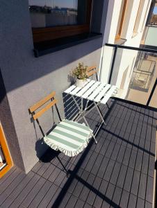 a table and a chair on a balcony at Apartament u Liska in Rumia