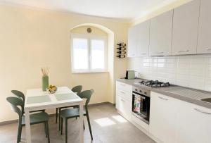 a kitchen with a table and a table and chairs at Dimora San Francesco in Sarzana