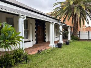 una casa con un portico anteriore con una palma di Bright Diamond Inn a Kimberley