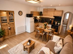 a living room with a couch and a table and a kitchen at La Marmotte appartement cosy centre Briancon proche Prorel in Briançon