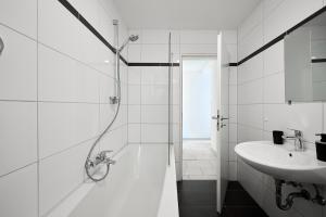 a white bathroom with a shower and a sink at SANO - Hagen - Hegel in Hagen +6 photos
