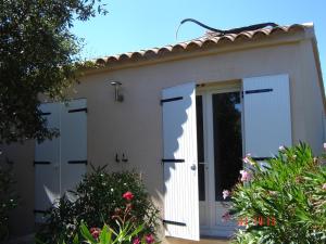 a white house with a door and some flowers at chambre residence stella d'oro in Porto-Vecchio