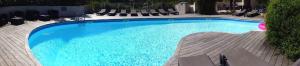 a large blue swimming pool with chairs around it at chambre residence stella d'oro in Porto-Vecchio