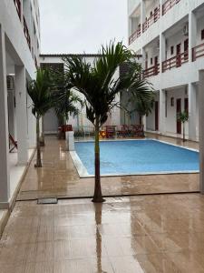 a pool in the middle of a building with palm trees at Apartamento a 50m da praia em Camocim CE in Camocim +6 photos