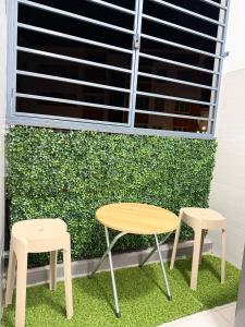 a table and two stools in front of a window at Nj Guesthouse in Tawau