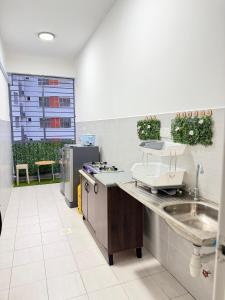 a kitchen with a sink and a counter top at Nj Guesthouse in Tawau