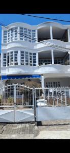 a white building with a fence in front of it at Life and memory in Blue Bay