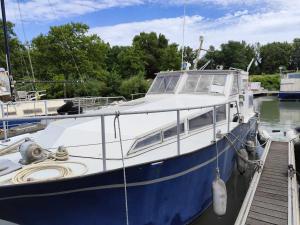 a blue and white boat docked at a dock at The Blue Boat in Valence