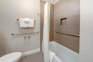 a bathroom with a tub and a toilet and a sink at Inviting Ocean View Condo Pono Kai Resort G104 in Kapaa +35 photos