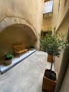 a bench sitting in a courtyard with potted plants at L'escarpin - Billiards - Historic in Romans-sur-Isère