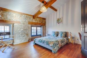 a bedroom with a bed and a stone wall at L'escarpin - Billiards - Historic in Romans-sur-Isère