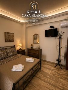 ein Schlafzimmer mit einem Bett, auf dem zwei Handtücher liegen in der Unterkunft Casa Blanco Metro Port Suites in Piräus