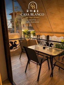 eine Terrasse mit Tisch und Stühlen auf einem Balkon in der Unterkunft Casa Blanco Metro Port Suites in Piräus