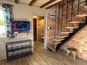 a living room with a staircase and a brick wall at Wczasy u Reni in Kopalino