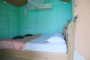 a bedroom with two beds in a room with blue walls at Phi Phi Oceanview Hill Bungalows in Phi Phi Islands