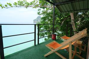 a balcony with a bench and a view of the water at Phi Phi Oceanview Hill Bungalows in Phi Phi Islands
