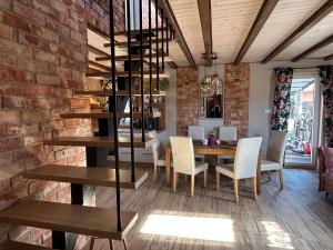 a dining room with a table and a brick wall at Wczasy u Reni in Kopalino