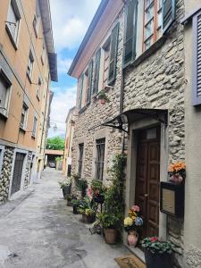 an alley with a stone building with a door and potted plants at B&B La Casa di Olga in Bobbio