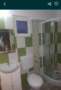a bathroom with a toilet and a sink and a shower at Căsuța de vacanță in Eforie Sud