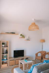 a living room with a couch and a tv at Just Like Home - Retorta do Pico in Caminha +17 photos