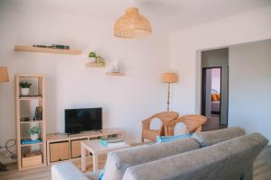 a living room with a couch and a tv at Just Like Home - Retorta do Pico in Caminha